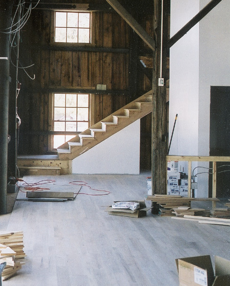 Inside the former barn building, plastered walls begin to appear. Note the new matched oak floor and the staircase against the far wall.