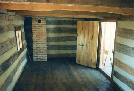 Finished interior of one room log cabin.