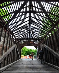 Volunteers converge on the Roddy Road covered bridge over Owens Creek near Thurmont early Saturday to replace the worn ribbed metal roofing with standing seam metal. (Photo by Sam Yu)