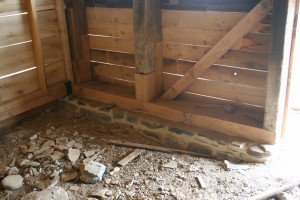 Forebay wall, with original posts spliced, new sill, new stone footing, and siding.
