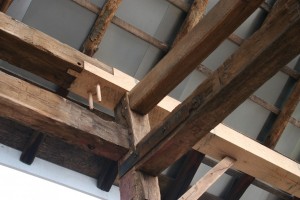 Replacement timbers are joined to originals using the traditional joinery.  Steel straps at unions show where existing joinery has been supplemented to resist tension loads.