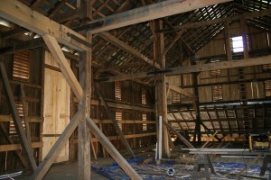 New roof, new doors, new siding, and repair timbers contrast, for now, against the original material.