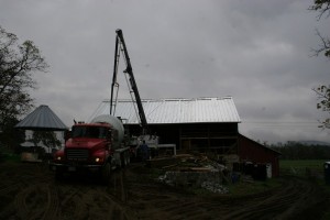 Bank barn sites are often difficult to manuver equipment along.  A concrete pumper helps us place our concrete more efficiently.