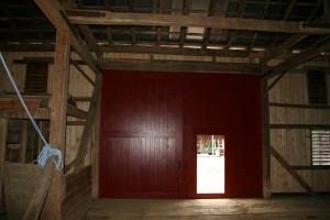 The new siding and doors make a striking contrast against the antique timber frame.